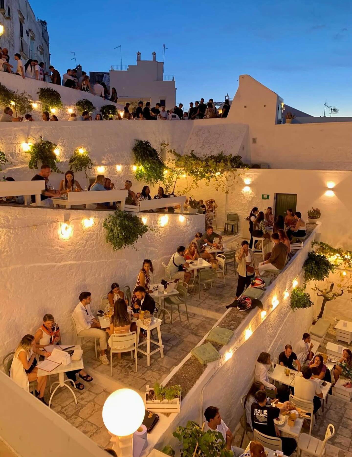 View of a charming bar in Ostuni, on a scalinata, at sunset.